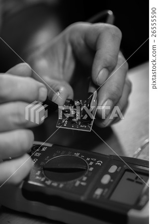 Male hands with multimeter and microcircuit 26555590