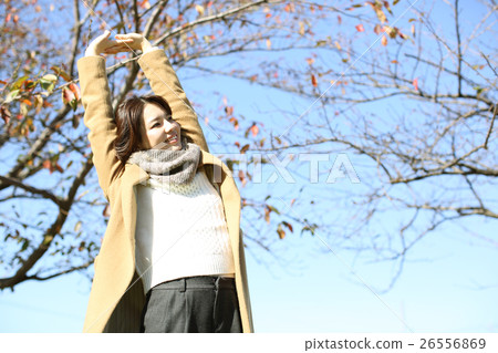 一個女人穿著一件外套伸展 一個女人穿著一件外套伸展 26556869