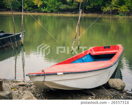 An old fishing boat fastened to a wooden sticks on An old fishing boat fastened to a wooden sticks on 26557318