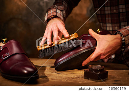 Man polishing leather shoes with brush 26560159