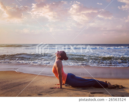 Woman practices yoga asana Urdhva Mukha Svanasana Woman practices yoga asana Urdhva Mukha Svanasana 26563524