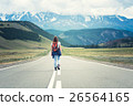 Lonely girl with a backpack walking along the road 26564165