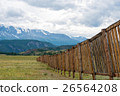 Long wooden fence in a field. In the distance the 26564208