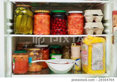 Pickled vegetables in jars in refrigerator 26564764
