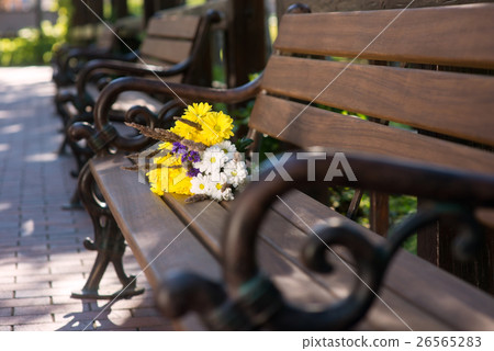 Bouquet on brown bench. 26565283