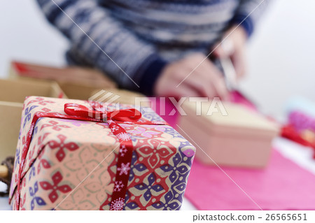young man wrapping a gift young man wrapping a gift 26565651