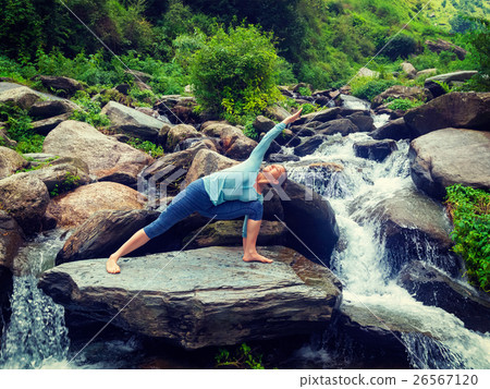 Woman practices yoga asana Utthita Parsvakonasana Woman practices yoga asana Utthita Parsvakonasana 26567120