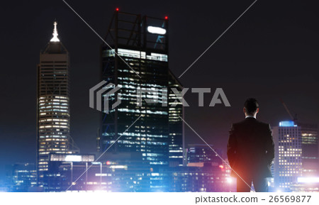 Businessman viewing night glowing city Businessman viewing night glowing city 26569877