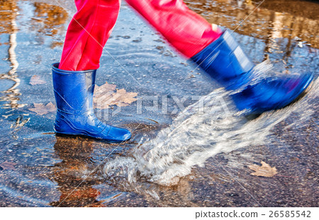 girl standing in a puddle of water splashes girl standing in a puddle of water splashes 26585542