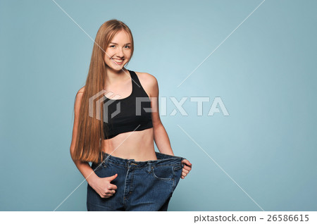 Women shows her weight loss. 26586615