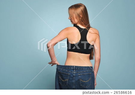 Fit young woman in loose jeans 26586616