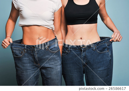 Women shows her weight loss. 26586617