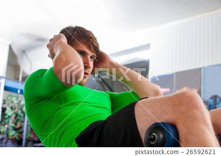 Man working his abdominal crunches with its own 26592621