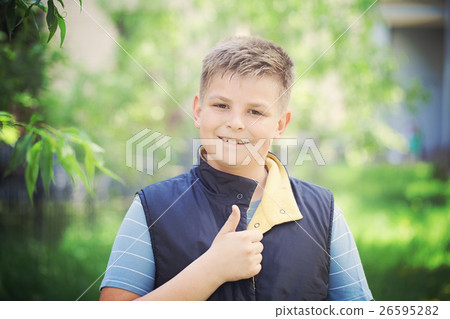 Young Boy Showing Thumbs Up Gesture Outdoors 26595282