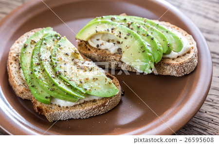 Toasts with tahini sauce and sliced avocado Toasts with tahini sauce and sliced avocado 26595608