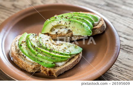 Toasts with tahini sauce and sliced avocado Toasts with tahini sauce and sliced avocado 26595609