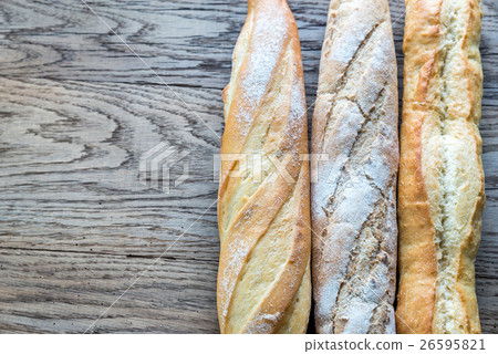 Three baguettes on the wooden background 26595821