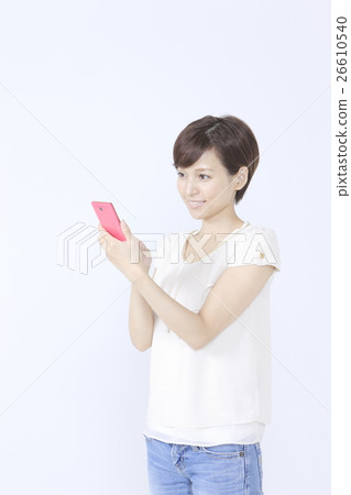 A young woman operating a smartphone A young woman operating a smartphone 26610540