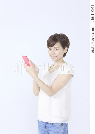 A young woman operating a smartphone A young woman operating a smartphone 26610541