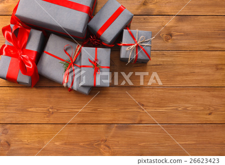Presents in gift boxes on wood frame background Presents in gift boxes on wood frame background 26623423