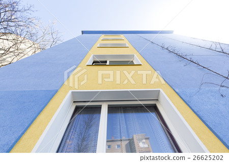 blue and yellow facade of an apartment house 26625202