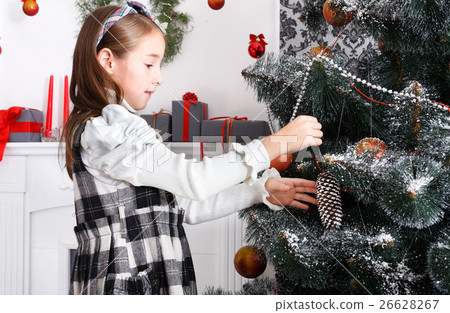 Pretty little girl decorate big christmas tree 26628267