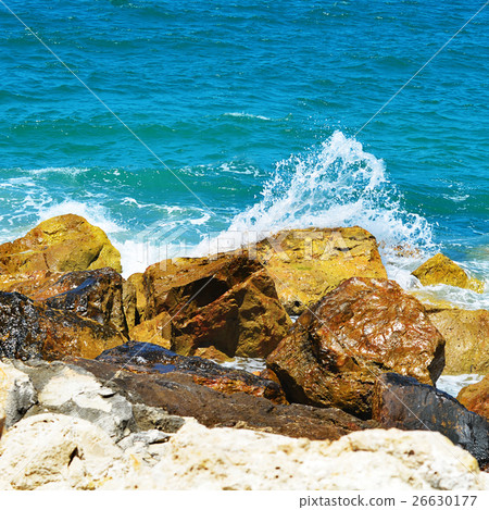 Sea waves break about stones 26630177