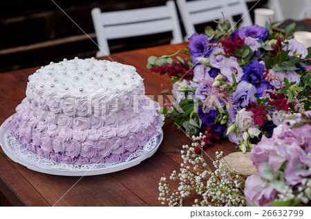festive wedding cake and a bouquet of flowers on 26632799