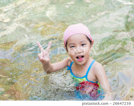 Asian girl is playing in the pool, victory fingers 26647239