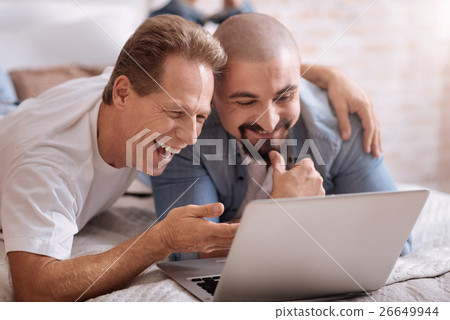 Joyful friends watching videos at home Joyful friends watching videos at home 26649944