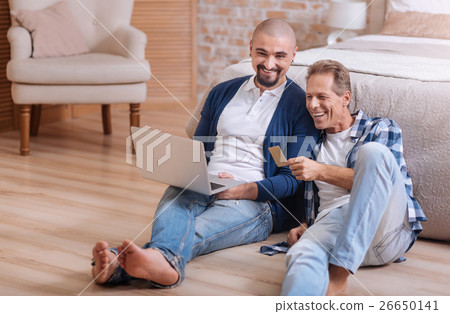 Gay couple looking at the laptop and having fun Gay couple looking at the laptop and having fun 26650141