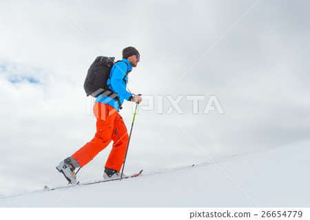 Man with ski mountaineering climb towards the summit 26654779