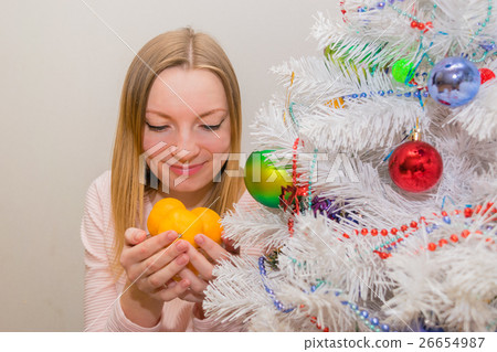 Girl with tangerines near Christmas tree Girl with tangerines near Christmas tree 26654987