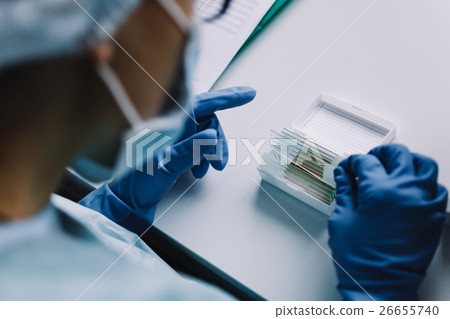 Crop hands putting microscope glasses in box Crop hands putting microscope glasses in box 26655740