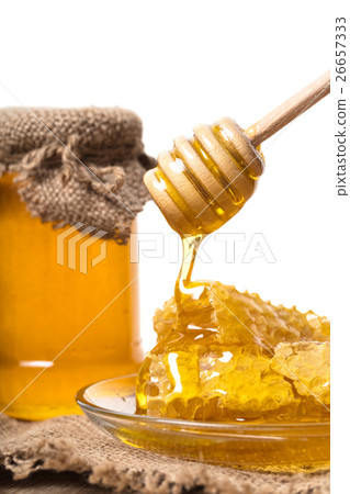 Honey dripping from wooden spoon Honey dripping from wooden spoon 26657333
