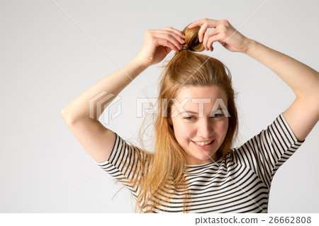 beautiful young caucasian woman corrects her hair 26662808