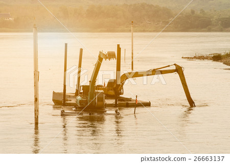Two shovel buckets on pontoon are dig mud. 26663137