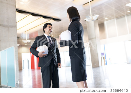 在大廳和談話拿著一件盔甲的女商人和商人 在大廳和談話拿著一件盔甲的女商人和商人 26664640