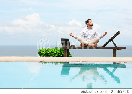 Businessman wearing a suit doing Yoga on the beach 26665708