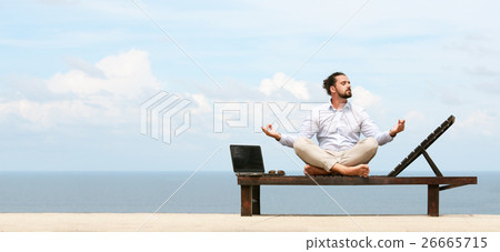 Businessman wearing a suit doing Yoga on the beach 26665715