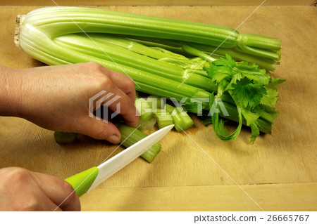 Slicing fresh celery on the old kitchen board 26665767