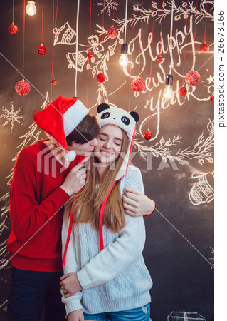 Happy couple in funny hats standing hugging on a Happy couple in funny hats standing hugging on a 26673166