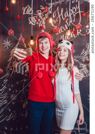 Happy couplein funny hats standing hugging and Happy couplein funny hats standing hugging and 26673190
