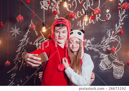 Happy couplein funny hats standing hugging and Happy couplein funny hats standing hugging and 26673192