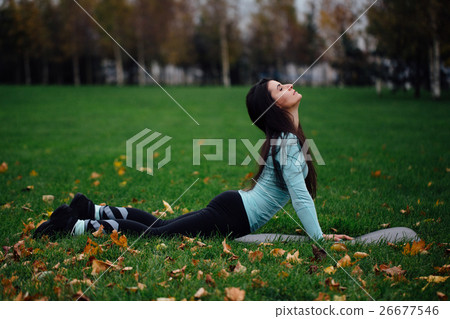 Beautiful girl stretching at the grass. Sporty 26677546