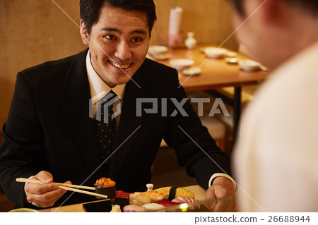 A man eating at a sushi bar A man eating at a sushi bar 26688944