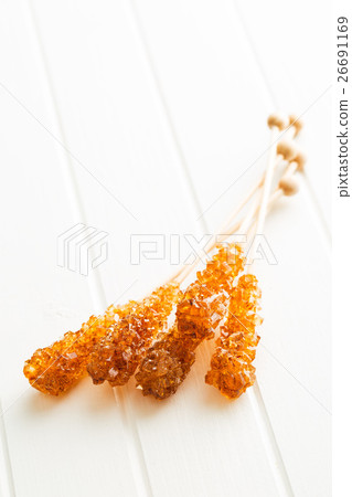 Brown amber sugar crystal on wooden stick. Brown amber sugar crystal on wooden stick. 26691169