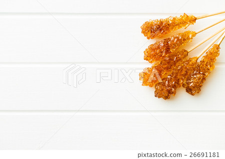 Brown amber sugar crystal on wooden stick. Brown amber sugar crystal on wooden stick. 26691181