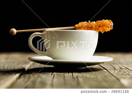 Sugar crystal on wooden stick and coffee cup. 26691188