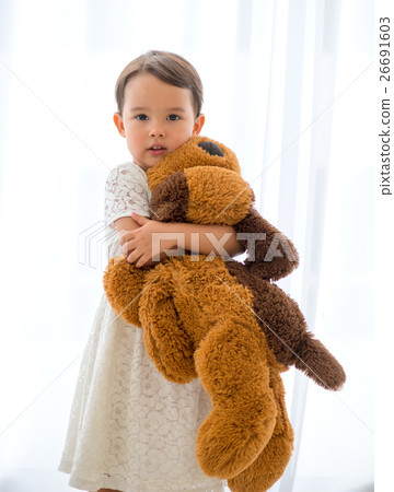 little happy girl hugging big brown teddy bear 26691603